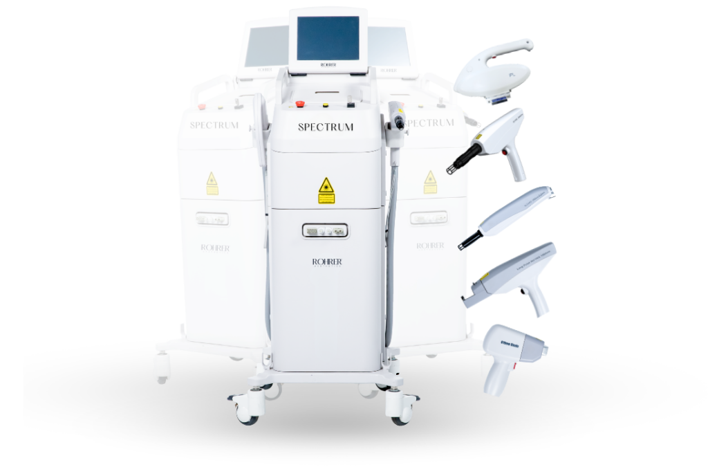 White Spectrum laser device by Rohrer Aesthetics with touchscreen display, control panel, and five detachable handpieces arranged on the right side, each designed for different skin treatments.